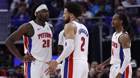 A Detroit Pistons game scene showing players on the bench during a trade period.