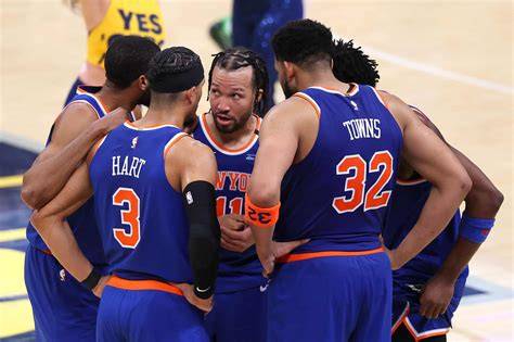 New York Knicks players discussing strategy during a timeout in the playoffs.