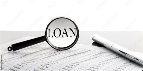 Loan fee documents laid out with a magnifying glass over them.