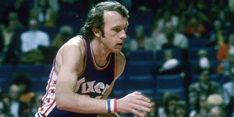 Billy Cunningham analyzing game footage with coaches
