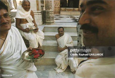 People dressed in simple, modest clothing attending a Jain ritual