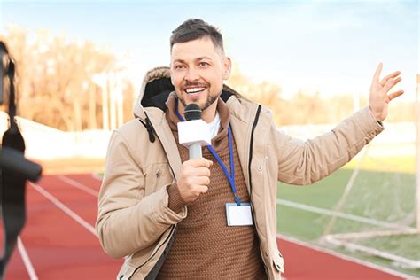 A sports journalist at a local sports event engaging with fans.