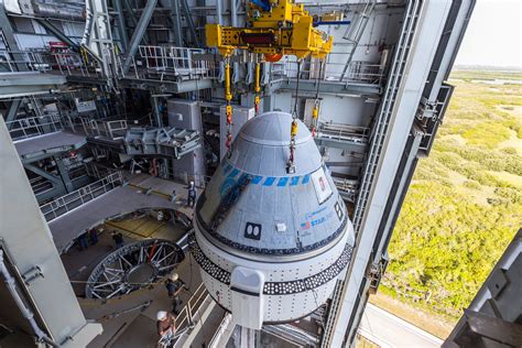 Engineers working on a Boeing Starliner spacecraft at a testing facility.
