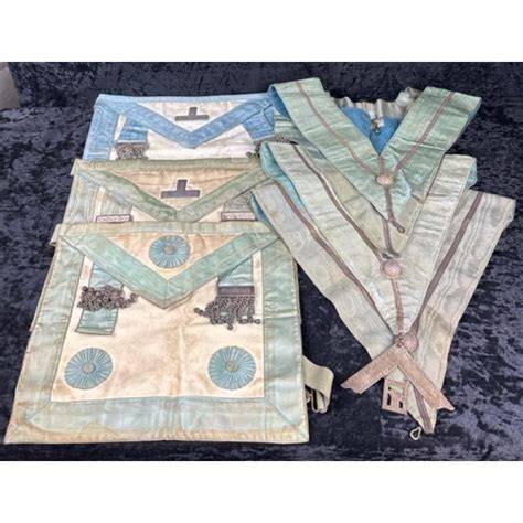 A variety of Masonic aprons and collars arranged neatly