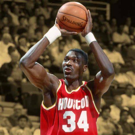 Hakeem Olajuwon dribbling the ball during a game.
