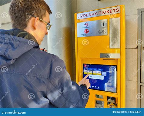A traveler purchasing a ticket from a public transport machine in Prague.