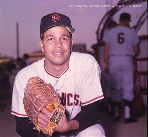 Juan Marichal poses with a baseball glove and a signed ball