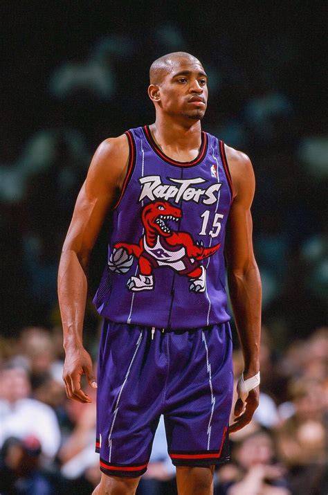 Vince Carter posing with fans in his Toronto Raptors jersey.