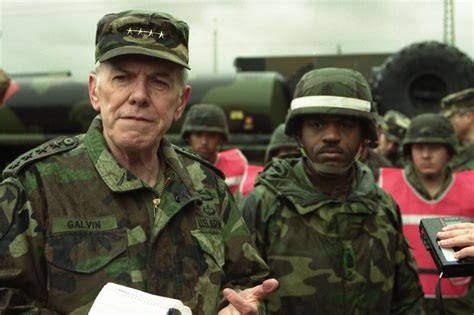 General John Galvin observing military exercises with soldiers and equipment
