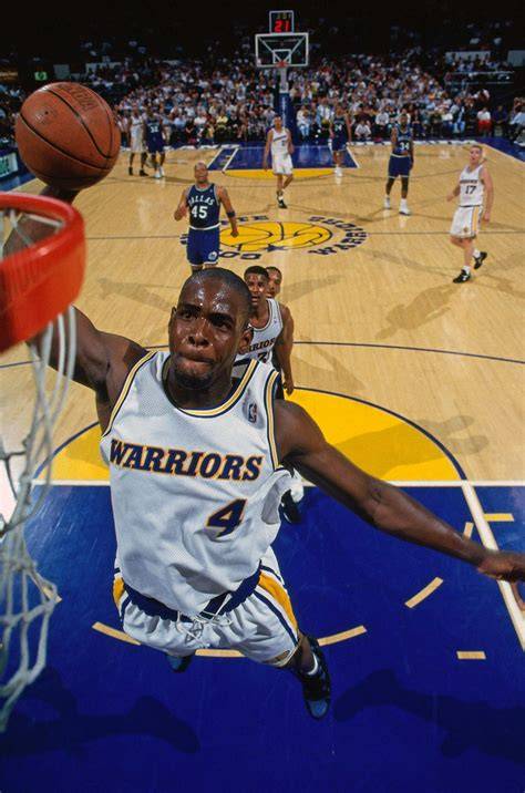 Chris Webber driving to the basket during a game for the Warriors.